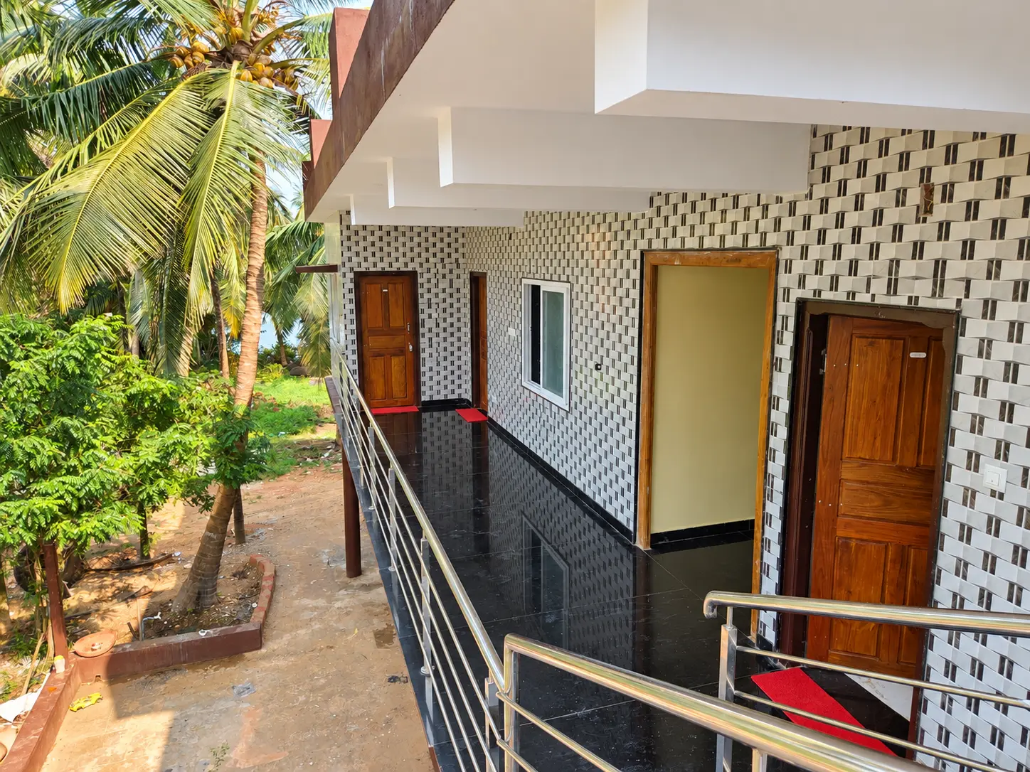 Tiled upper-floor walkway with steel railings leading to the rooms